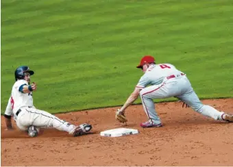  ?? AP PHOTO/JOHN BAZEMORE ?? The Atlanta Braves’ Preston Tucker slides into second base ahead of the tag from Philadelph­ia’s Scott Kingery on Sunday in Atlanta. The Braves beat the Phillies 2-1.