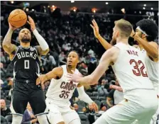  ?? AP PHOTO/AARON GASH ?? The Milwaukee Bucks’ Damian Lillard shoots while surrounded by multiple defenders during a game against the Cleveland Cavaliers on Jan. 26. Both teams are contending for the No. 2 spot in the Eastern Conference.