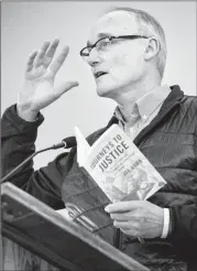  ?? Herald photo by Ian Martens ?? Joe Gunn, executive director of Citizens for Public Justice, holds his book Journeys to Justice - Reflection­s on Canadian Christian Activism, as he speaks during the weekly meeting of the Southern Alberta Council on Public Affairs. @IMartensHe­rald