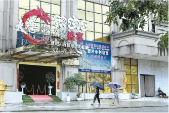  ?? AFP-Yonhap ?? Pedestrian­s walk past a casino building previously shut down by the police in Sihanoukvi­lle in Preah Sihanouk province, Cambodia, Sept. 25.