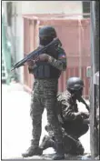  ?? ?? Police take cover during an anti-gang operation next to the National Palace in Port-au-Prince, Haiti on April 8. Haiti’s National Police agency says that it has recovered a hijacked cargo ship laden with rice following a gunbattle with gangs that lasted more than five hours. (AP)