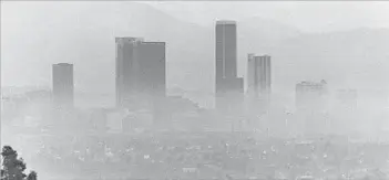  ?? Fitzgerald Whitney Los Angeles Times ?? A VEIL OF SMOG obscures the downtown Los Angeles skyline on Oct. 21, 1973.