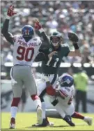  ?? MATT ROURKE — THE ASSOCIATED PRESS ?? Philadelph­ia Eagles' Carson Wentz ( 11) tries to pass against New York Giants' Jason PierrePaul ( 90) as Jonathan Casillas
( 52) tackles during the first half of an NFL football game, Sunday, Sept. 24, 2017in Philadelph­ia.