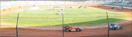  ??  ?? Waihi driver Mark Hutchins’ Super Saloon, 53m, and other cars helping dry out the track after heavy rain at the Baypark Speedway. The South Pacific Super Saloon Car Championsh­ip is on January 5.