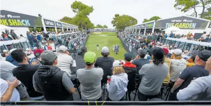  ?? Photos / Getty Images, Cam McMillan. ?? The Watering Hole is a superb set-up. Stands all the way down the par-three with three levels; Kiwi Danny Lee, of Iron Heads GC chips, as the gallery looks on; crowds followed Aussie Cam Smith.