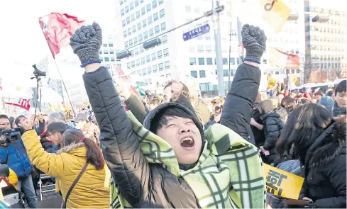  ??  ?? NO MERCY: South Koreans in front of the National Assembly in Seoul cheer after President Park was impeached over influence-peddling allegation­s.