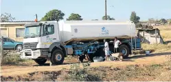  ?? Picture: JACKIE CLAUSEN ?? ’DELIVERY’: People fill water containers from an Aqua water tanker outside a Wartburg depot. Residents in the area haven’t had tap water for two weeks