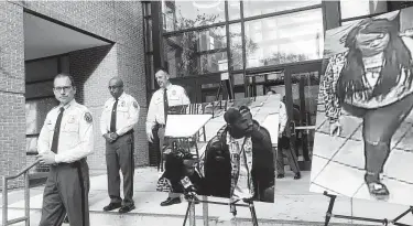  ?? Michael Kunzelman / Associated Press ?? Prince George’s County Police Chief Hank Stawinski stands by a photo of a man who is suspected of killing a man at a Popeyes restaurant in Maryland and a photo of a woman who was apparently with the suspect.