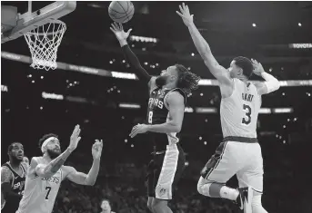  ??  ?? San Antonio Spurs guard Patty Mills shoots against Los Angeles Lakers guard Josh Hart and center JaVale McGee during the second half of their NBA clash at Staples Center in Los Angeles on Monday. The Spurs won 143-142 in overtime. — Reuters