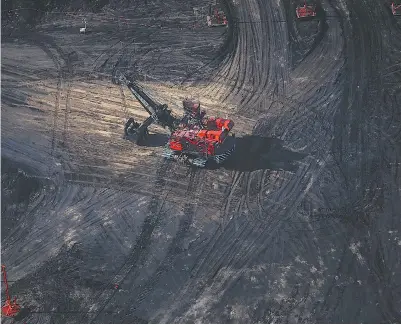  ?? BEN NELMS / BLOOMBERG FILES ?? A bucket loader at the Suncor oilsands mine near Fort McMurray, Alta. Major oilsands producers are expected to weather
the drop in crude prices, but there are worries investment may be affected by political uncertaint­y in Alberta.