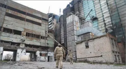  ?? ?? Ukrainian soldiers walk outside a still burning grain silo in Snihurivka, Kherson district, on Wednesday.