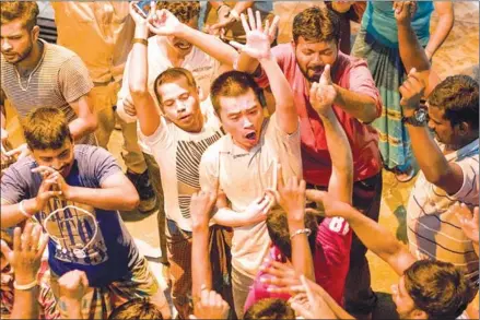  ?? PHILIPP ALDRUP/AKANGA FILM ASIA/AFP ?? Singaporea­n actor Liu Xiaoyi (centre) acts during filming for ‘A Land Imagined’ in Singapore.