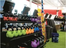  ?? KASSI JACKSON/HARTFORD COURANT ?? Kettlebell­s and other workout items rest next to the turf floor at The Edge Fitness Club in June 2020, in West Hartford, Connecticu­t.