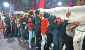  ??  ?? In the morning, monks and believers carry the rolled-up thangka from the monastery on the opening day of Shoton Festival, a traditiona­l annual gala in Lhasa, the Tibet autonomous region.