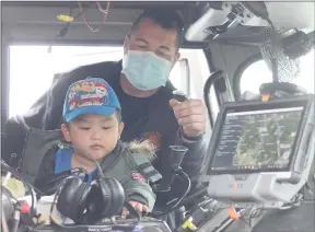  ?? Keith Bryant/The Weekly Vista ?? Bella Vista Make-A-Wish recipient Vincent Lee (foreground), 4, tries out a few different siren tones on a Bella Vista fire truck with help from Capt. Brian Lasiter.