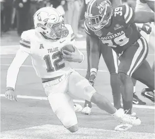  ?? STEPHEN M. DOWELL/ORLANDO SENTINEL ?? Tulane quarterbac­k Justin McMillan (12) falls into the end zone for a touchdown late in the Green Wave’s win over Louisiana during the Cure Bowl Saturday at Camping World Stadium. College football leaders see a bright future for the relatively young bowl game.