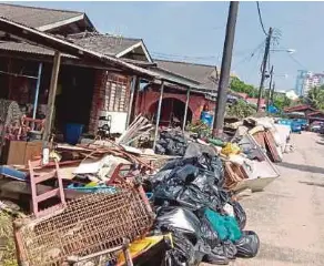  ?? (Foto Omar Ahmad/bh) ?? Sisa pukal mangsa banjir di sepanjang jalan Kampung Seri Serdang Baru, Johor Bahru.