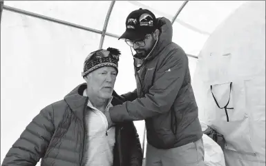  ?? PRAKASH MATHEMA / AGENCE FRANCE-PRESSE ?? Doctor Suvash Dawadi checks on a patient at the Everest ER tent clinic at Qomolangma Base Camp, some 140 kilometers northeast of