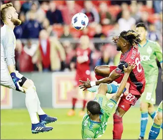  ??  ?? Seattle goalkeeper Stefan Frei leaps to make a save on Toronto’s Tosaint Ricketts during the second half of the
Sounders’ 2-1 win Wednesday in Toronto. (AP)