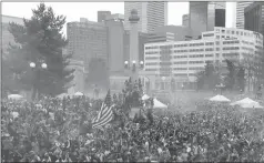  ?? Associated Press ?? In this April 20, 2013, file photo, members of a crowd numbering tens of thousands smoke marijuana during the 4/20 pro-marijuana rally at Civic Center Park in Denver. According to a report released on Monday, the day marijuana users celebrate as their...