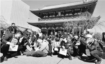  ??  ?? This photo taken on March 8 shows foreigners sheltering during a disaster drill at Sensoji Temple in Tokyo. — AFP photo