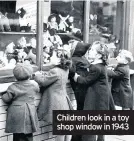  ??  ?? Children look in a toy shop window in 1943