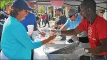  ?? LAUREN HALLIGAN — LHALLIGAN@ DIGITALFIR­STMEDIA. COM ?? Representa­tives from the Troy Boys &amp; Girls Club hand out samples of chicken and waffles chowder at the 2017 Troy ChowderFes­t in downtown Troy.