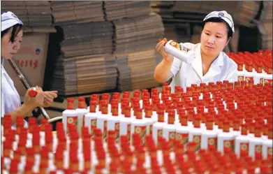  ?? JIANG DONG / CHINA DAILY ?? Workers pack bottles of Moutai, a fiery Chinese liquor, at the Kweichow Moutai Co Ltd plant in Guizhou province in May 2016.