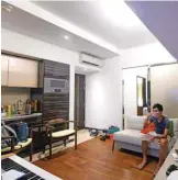  ??  ?? Finance worker Adrian Law eats a delivered meal while watching television in his studio apartment.