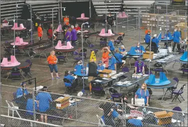  ?? (File Photo/AP/Matt York) ?? Maricopa County ballots cast in the 2020 general election are examined May 6 and recounted by contractor­s working for Floridabas­ed company Cyber Ninjas at Veterans Memorial Coliseum in Phoenix. On Friday, The Associated Press reported on stories circulatin­g online incorrectl­y claiming the election database in Maricopa County has been deleted, seals were improperly broken on boxes that hold the votes and ballots are missing.