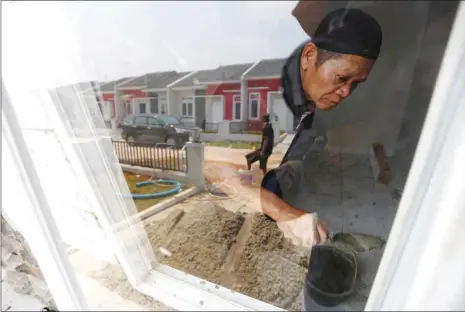  ??  ?? A labourer works on the interior of a new house at a housing project in Tajur Halang, Jakarta. As Indonesia’s central bank drives up interest rates to defend a fragile currency, governor Perry Warjiyo is banking on a revival of the sluggish property...