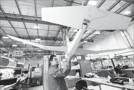  ?? Photograph­s by Al Seib Los Angeles Times ?? OSCAR GONZALEZ, a test technician at AeroVironm­ent in Simi Valley, inspects parts during assembly of the Puma AE drone.