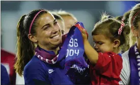  ?? ASSOCIATED PRESS FILE PHOTO ?? United States’ Alex Morgan holds her daughter, Charlie, as she listens to Cindy Parlow Cone, president of the U.S. Soccer Federation, speak during an event with the federation, U.S. Women’s National Team Players Associatio­n and the U.S. National Soccer Team Players Associatio­n at Audi Field in Washington, Sept. 6, 2022.