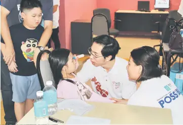  ??  ?? A child having her eyes checked during the screening.