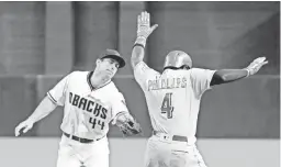  ?? ROSS D. FRANKLIN/AP ?? The Diamondbac­ks' Paul Goldschmid­t (44) reaches to tag out the Reds' Brandon Phillips (4) as Phillips runs to first base during Friday’s game.