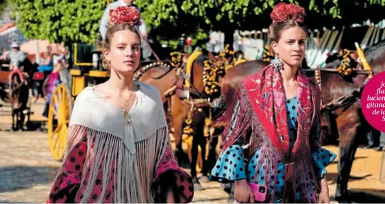  ?? ?? Dos jóvenes flamencas luciendo traje de gitana por el real de la Feria de Sevilla