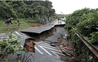  ?? ?? Water everywhere: A road washed away in Durban on Tuesday as downpours wreak havoc with infrastruc­ture in KwaZuluNat­al.