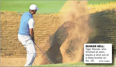  ?? Getty Images ?? BUNKER HELL: Tiger Woods, who finished at even, blasts a shot out of a deep bunker on No. 18.