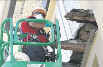  ?? Jeff Chiu
Associated Press ?? A CREW MEMBER works on what remains of a f if th- f loor balcony at the Library Gardens apartment complex in Berkeley. Dry rot feasted on the balcony’s wood joists until the cantilever­ing gave way, killing six.