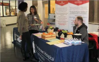  ??  ?? Dietitian Shreya Patel holds a food plate which showcases proportion sizes that should be used for healthy eating during a combined wellness fair and blood drive held at Montgomery County Community College in Pottstown. Tower Health had a table about healthy lifestyle choices.