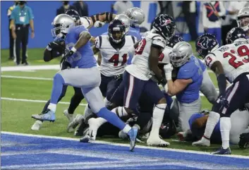  ?? AP PHOTO/DUANE BURLESON ?? Detroit Lions running back Adrian Peterson breaks through the Houston Texans defense for a 1-yard touchdown run during the first half of an NFL football game, Thursday in Detroit.
