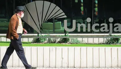  ?? EFE ?? Un hombre pasa ayer frente a la sede central de Unicaja en Málaga