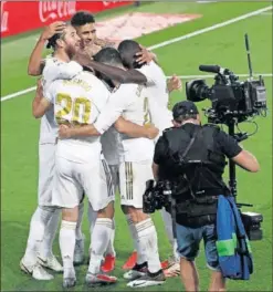  ??  ?? El Real Madrid celebra un gol bajo la atenta mirada de un cámara.