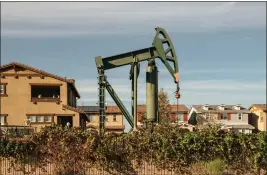  ?? PABLO UNZUETA — CALMATTERS ?? An active oil derrick near homes in the city of Signal Hill in Los Angeles County in 2022.