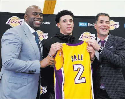  ?? Jae C. Hong ?? The Associated Press Highly touted UCLA point guard Lonzo Ball, center, with Los Angeles Lakers president of basketball operations Magic Johnson, left, and general manager Rob Pelinka. Ball was taken by the Lakers with the No. 2 pick in last week’s NBA...