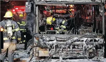  ??  ?? FIREFIGHTE­RS examine a bus in the town of Holon, near Tel Aviv, that was hit by rockets fired from Gaza.
| AFP