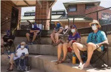  ?? Photos by Rachel Ellis, The Denver Post ?? Travis and Jen Crouch, right, sit apart from other spectators as they watch their daughter play in an 18U club softball game on Saturday.