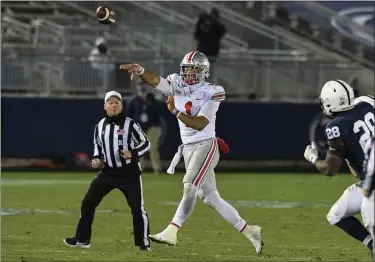  ?? BARRY REEGER — THE ASSOCIATED PRESS ?? Ohio State quarterbac­k Justin Fields passes while being chased by Penn State defensive end Jayson Oweh on Oct. 31.