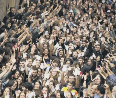  ??  ?? Catalan independen­ce supporters raise their hands, some painted in white as a symbol of protest, during a rally outside the city hall of Girona, Spain, yesterday after Spanish riot police tried to halt a disputed independen­ce referendum on Sunday.