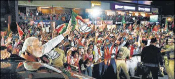  ?? ANI ?? PM Modi waves to the people during a roadshow in Valsad on Saturday.